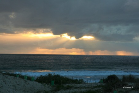 Sun bursting through the rainy clouds out at sea